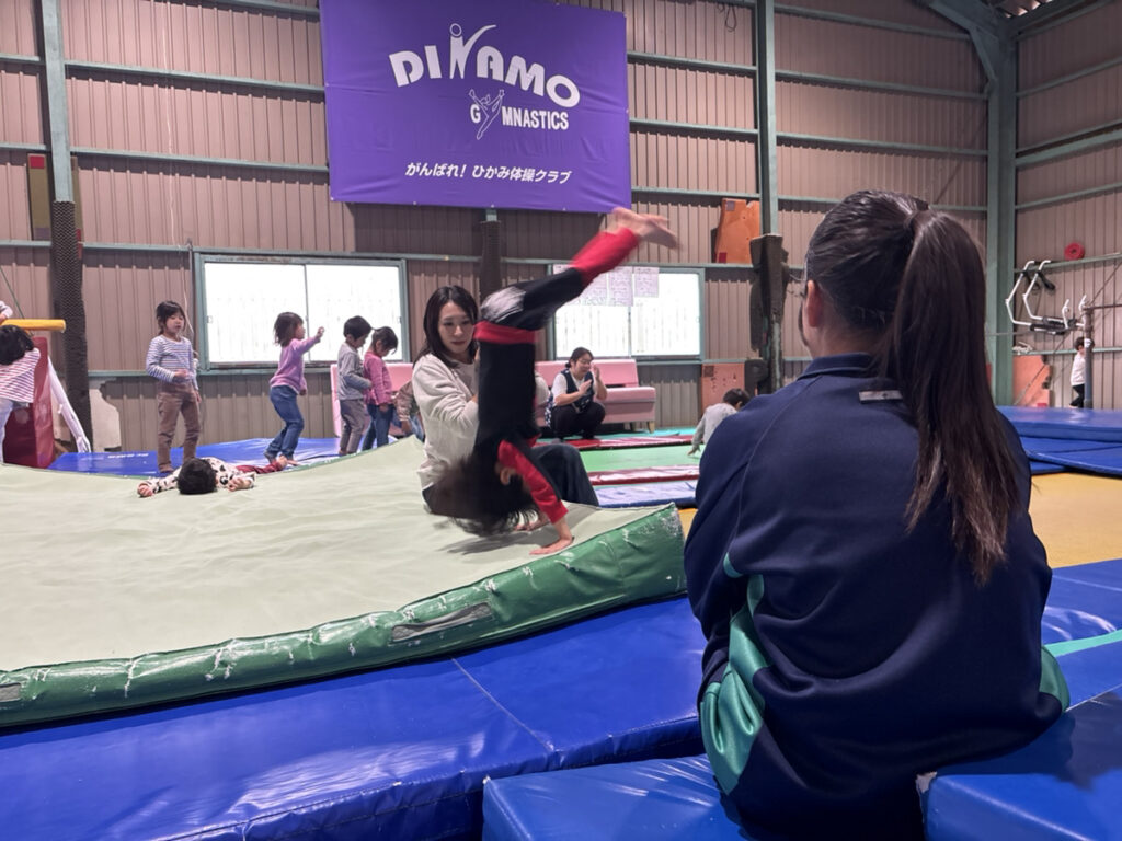 ディナモ体操クラブ氷上校でマット運動を披露する園児たちと見学するインターンシップのお姉さん先生
