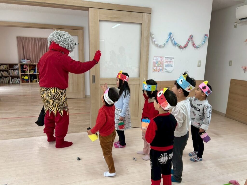 兵庫県丹波市氷上のタイムカプセル保育園の節分会。仲良くなった赤鬼に手を振って「バイバイ」と見送りをする子どもたちの様子