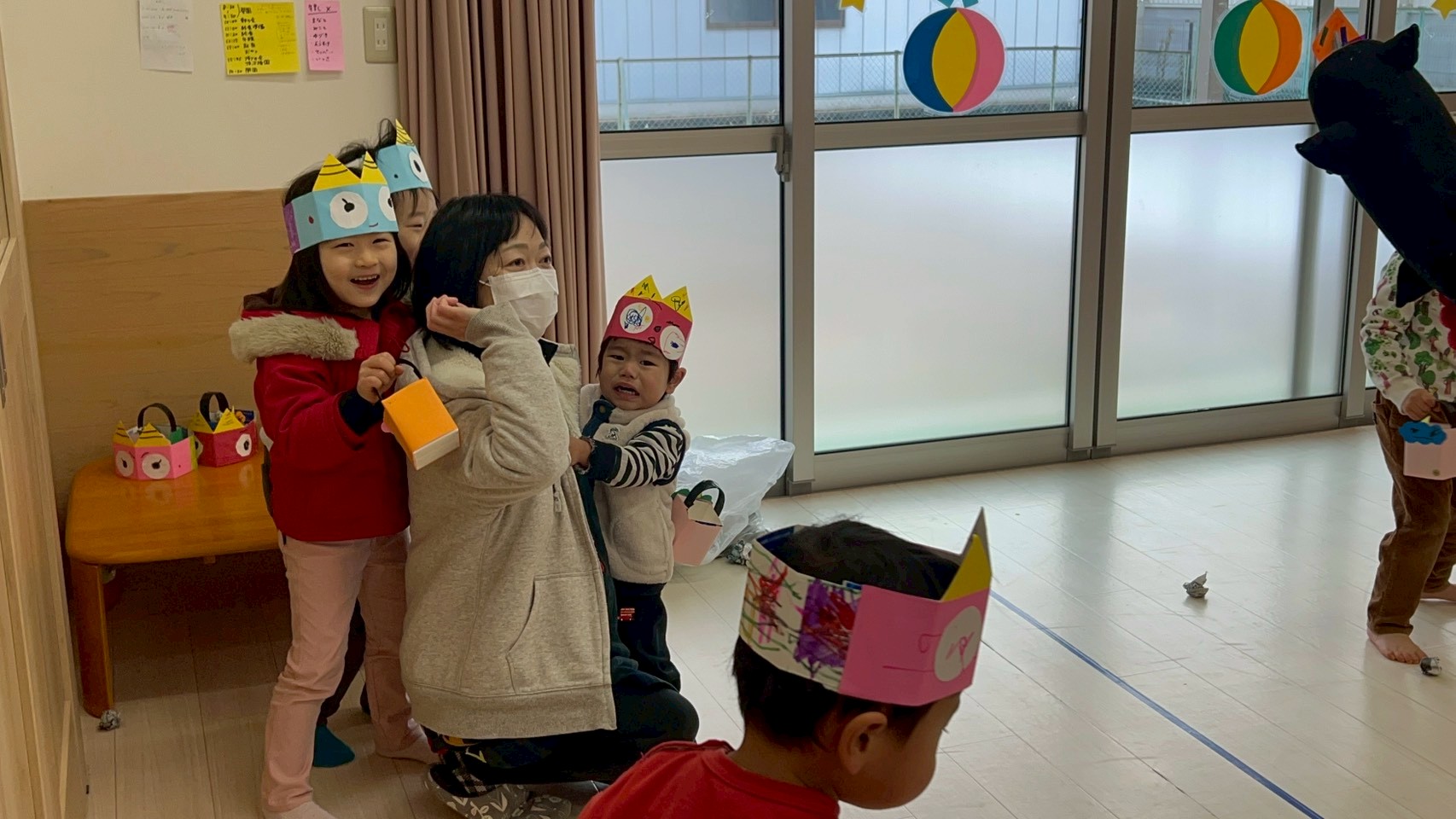兵庫県丹波市氷上のタイムカプセル保育園の節分会。鬼の登場に驚き、保育士の背中に隠れて様子を伺う子どもたちの様子